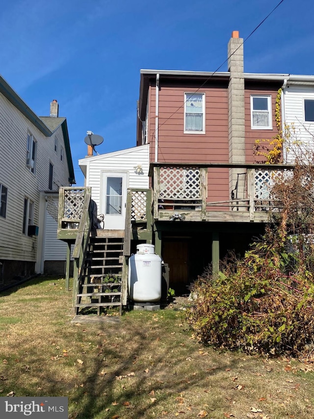 rear view of property with a yard and a wooden deck