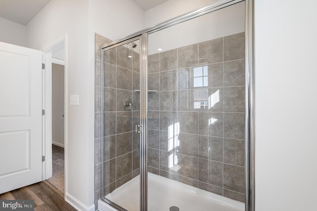 bathroom featuring wood-type flooring and a shower with door