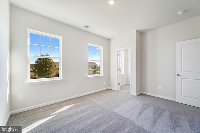 spare room featuring light carpet