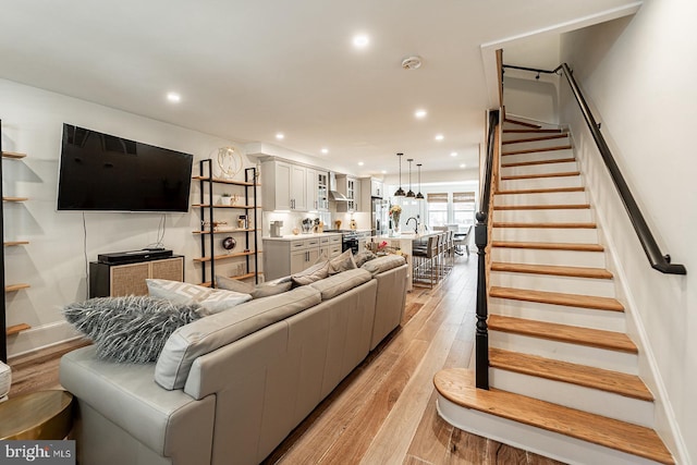 living room featuring sink and light hardwood / wood-style flooring