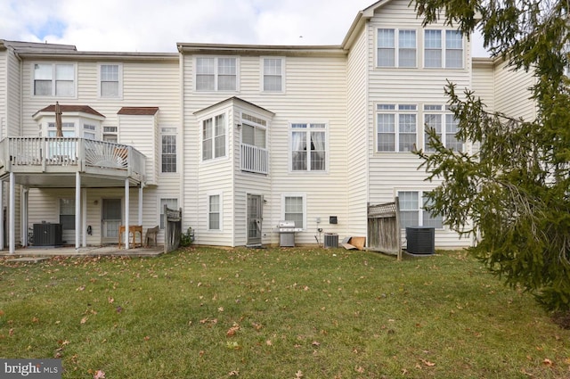 back of house featuring a lawn and central AC