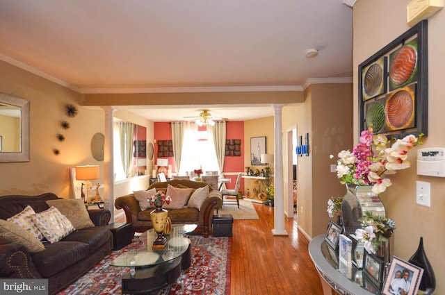 living room with ceiling fan, wood-type flooring, crown molding, and decorative columns