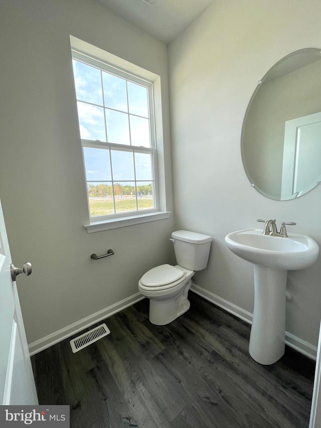 bathroom featuring wood-type flooring and toilet