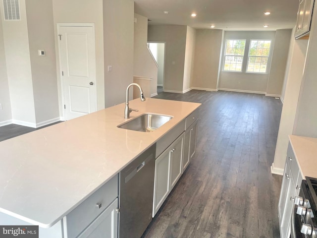 kitchen featuring gray cabinetry, sink, stainless steel appliances, dark hardwood / wood-style floors, and a kitchen island with sink