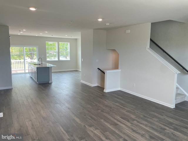 unfurnished living room with dark hardwood / wood-style floors and sink