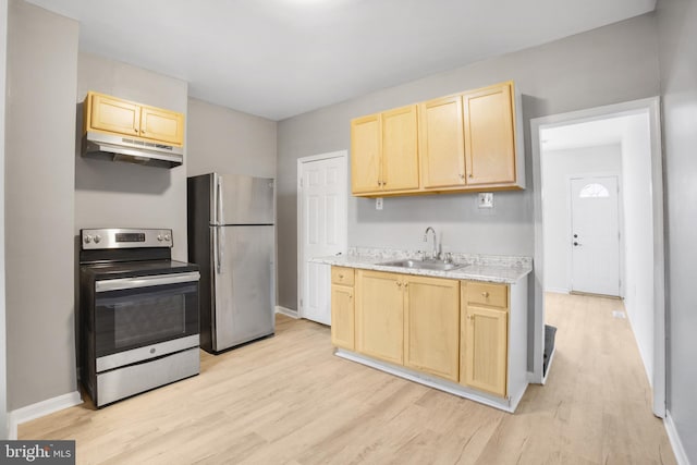 kitchen featuring light stone countertops, appliances with stainless steel finishes, light wood-type flooring, sink, and light brown cabinets