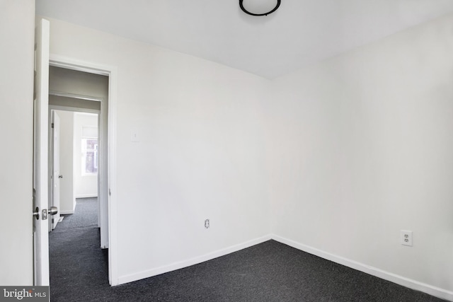 empty room with dark colored carpet