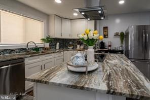 kitchen with white cabinets, dishwasher, and dark stone countertops