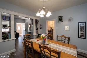 dining space with dark wood-type flooring and a chandelier