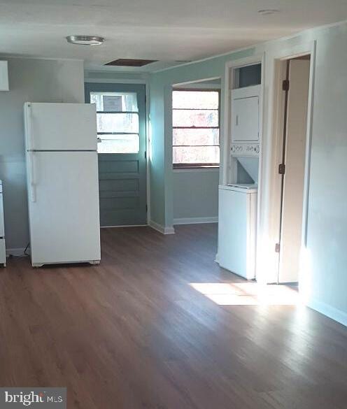 kitchen with dark hardwood / wood-style floors, white fridge, and stacked washer and dryer