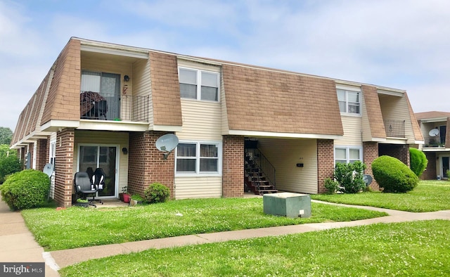 multi unit property with a balcony and a front lawn