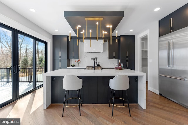 3113 Circle Hill Rd, Alexandria, VA 22305 - kitchen featuring built in refrigerator, tasteful backsplash, light wood-type flooring, light stone countertops, and a spacious island