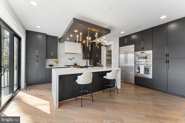 3113 Circle Hill Rd, Alexandria, VA 22305 - kitchen with appliances with stainless steel finishes, light countertops, tasteful backsplash, dark cabinets, and light wood finished floors