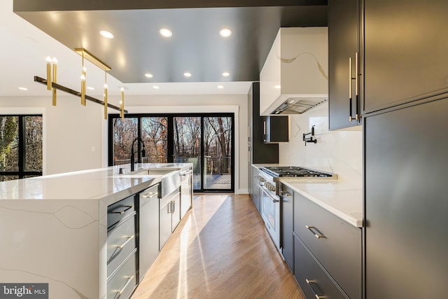 kitchen featuring custom exhaust hood, high end appliances, plenty of natural light, and hanging light fixtures