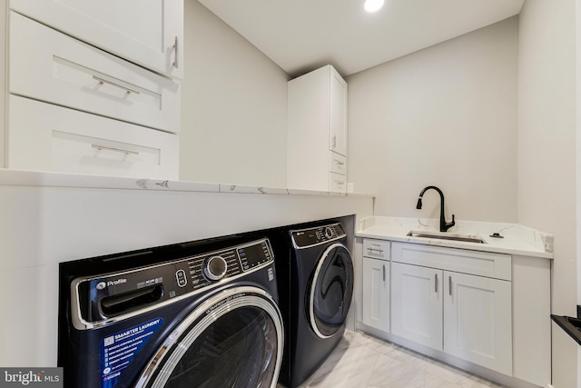 laundry area with washer and dryer, cabinets, and sink