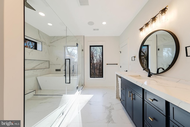 bathroom featuring vanity and independent shower and bath