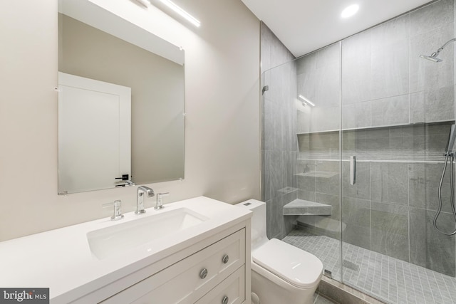 bathroom featuring vanity, an enclosed shower, and toilet