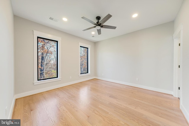 empty room with ceiling fan and light hardwood / wood-style floors