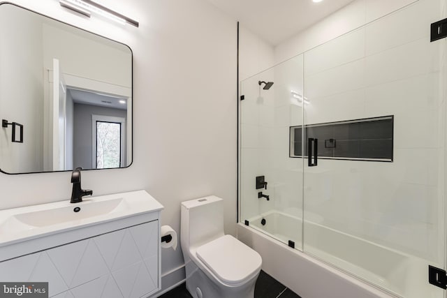 full bathroom featuring vanity, toilet, and shower / bath combination with glass door