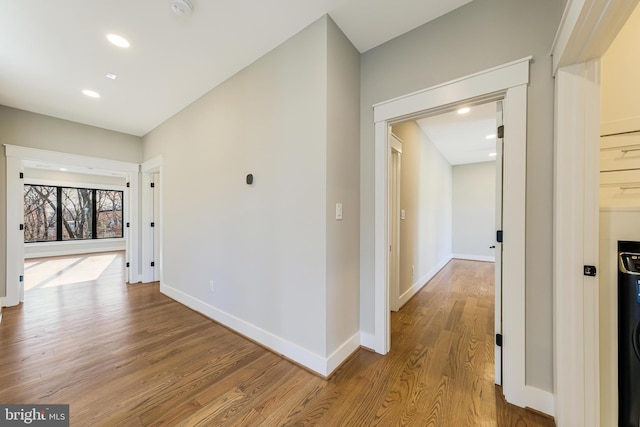 hallway featuring washer / clothes dryer and light hardwood / wood-style flooring