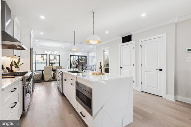 kitchen featuring a large island, sink, white cabinets, and stainless steel appliances