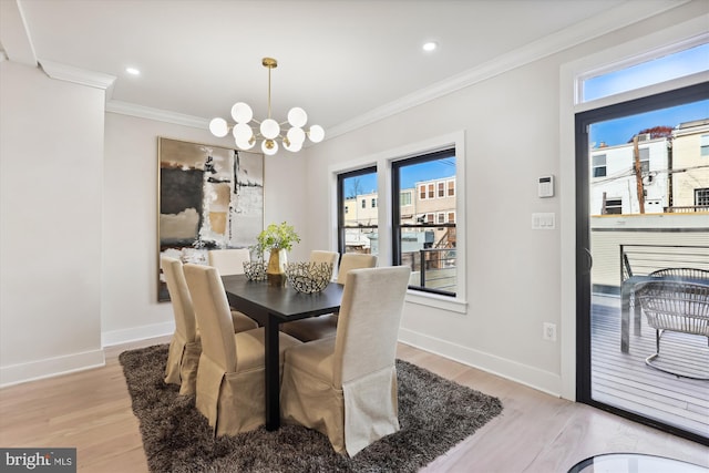 dining space featuring light hardwood / wood-style flooring, crown molding, and a notable chandelier