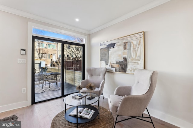 living area featuring hardwood / wood-style flooring and crown molding