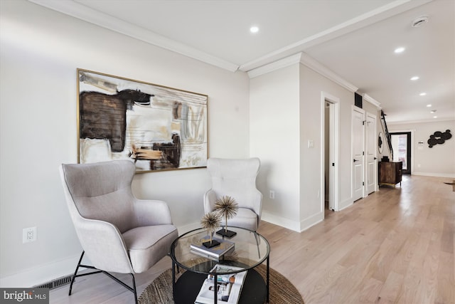 sitting room with light hardwood / wood-style floors and ornamental molding