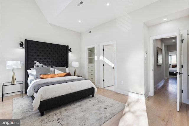 bedroom featuring light wood-type flooring, a spacious closet, and a closet