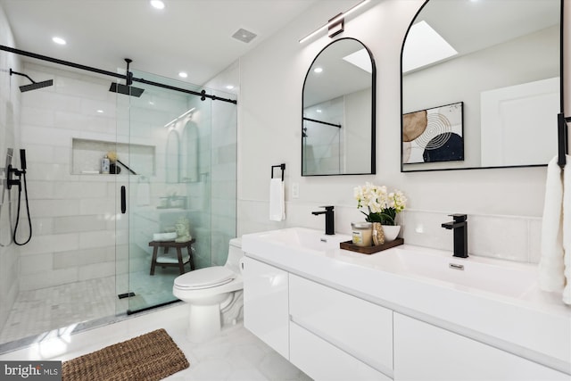 bathroom featuring vanity, toilet, and a shower with shower door