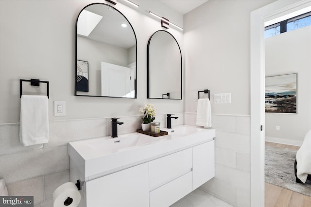 bathroom with vanity, tile walls, and hardwood / wood-style flooring