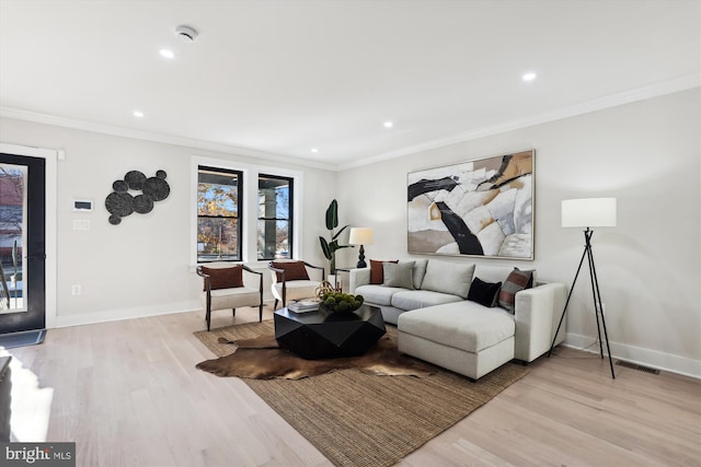 living room featuring crown molding and light hardwood / wood-style flooring