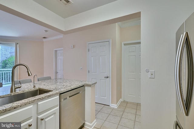 kitchen with light stone countertops, appliances with stainless steel finishes, sink, light tile patterned floors, and white cabinets