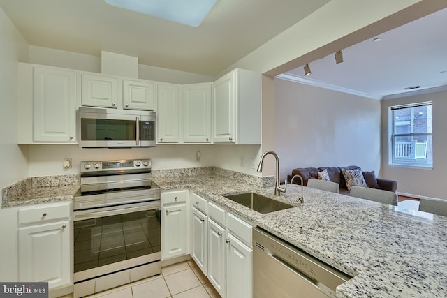 kitchen featuring appliances with stainless steel finishes, crown molding, sink, white cabinetry, and light tile patterned flooring