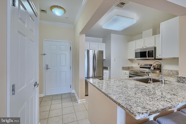 kitchen featuring a kitchen breakfast bar, kitchen peninsula, white cabinetry, and appliances with stainless steel finishes