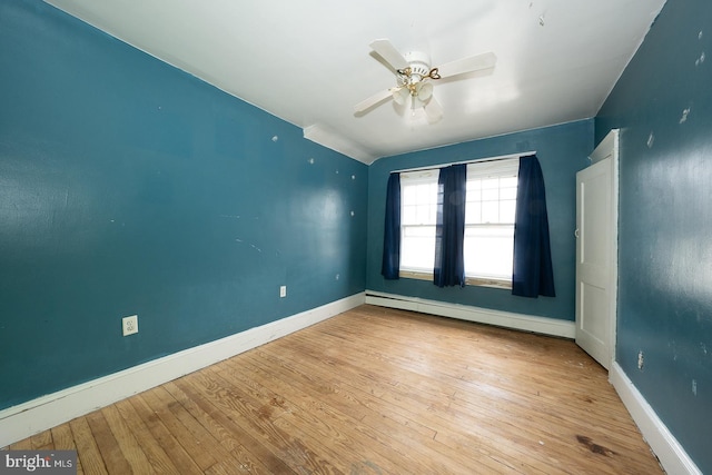 spare room featuring baseboard heating, ceiling fan, and light wood-type flooring