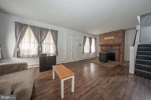 living room with a baseboard radiator, a wood stove, and dark hardwood / wood-style floors