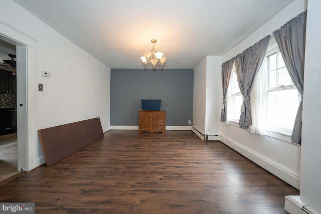 unfurnished living room featuring plenty of natural light, dark wood-type flooring, a baseboard radiator, and an inviting chandelier