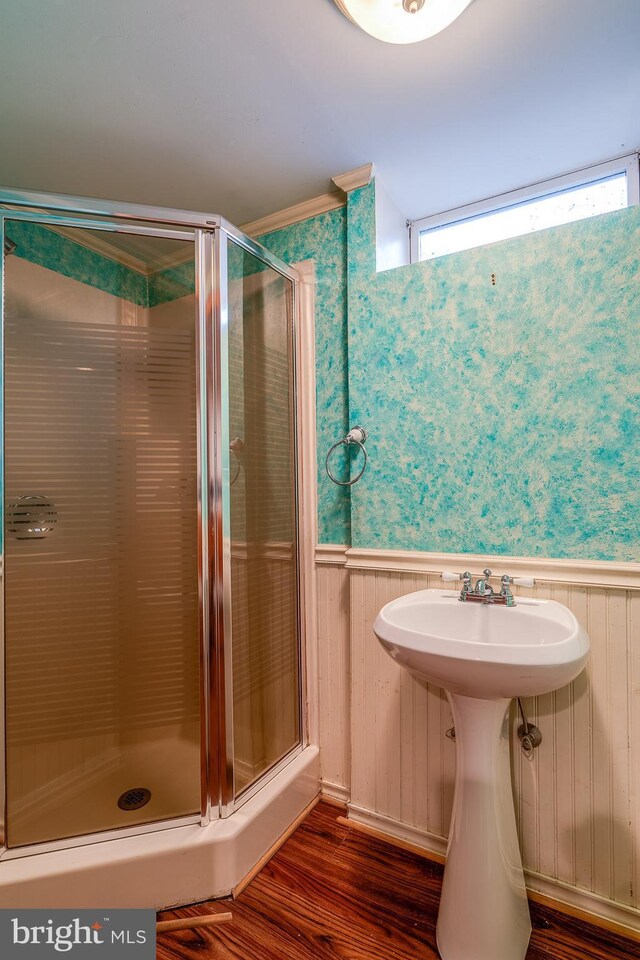 bathroom featuring wooden walls, hardwood / wood-style flooring, and a shower with shower door