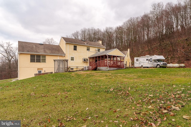 back of house featuring a wooden deck and a lawn