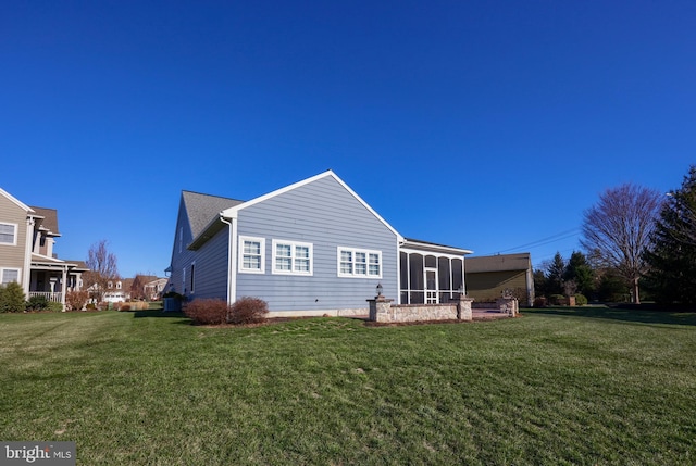 rear view of house with a sunroom and a yard