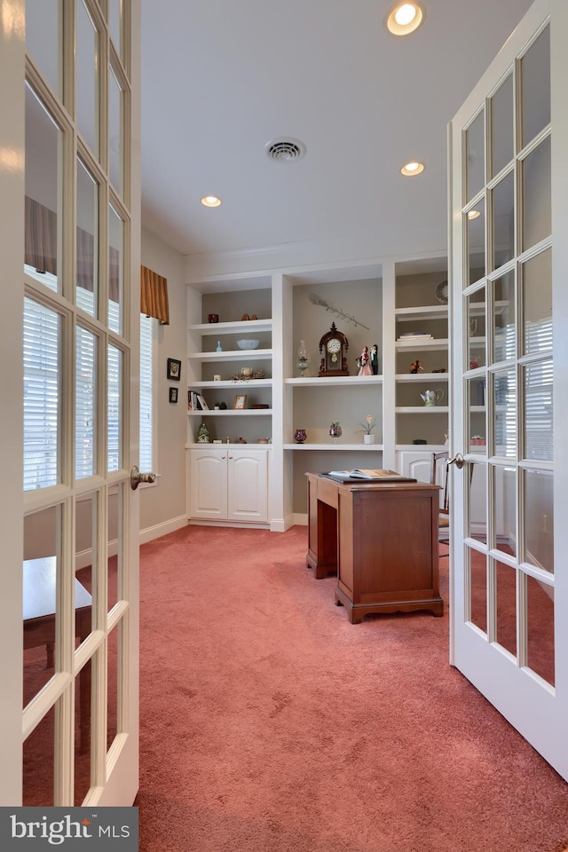 unfurnished office featuring carpet flooring, french doors, and built in shelves