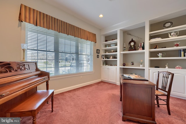 home office featuring built in shelves and carpet