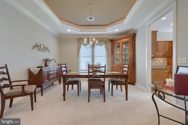 dining space with light carpet, a raised ceiling, crown molding, and a notable chandelier