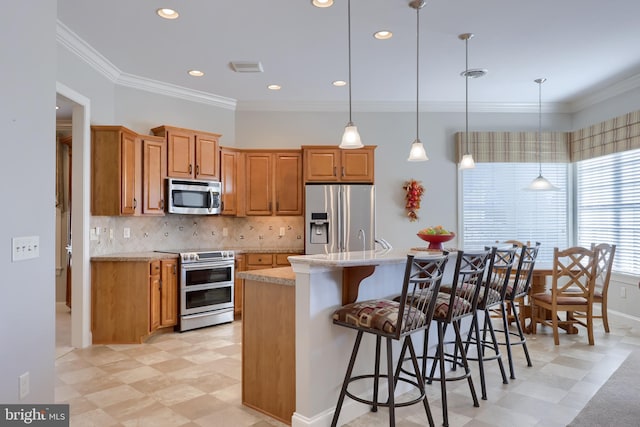 kitchen featuring appliances with stainless steel finishes, a center island, light stone counters, and hanging light fixtures