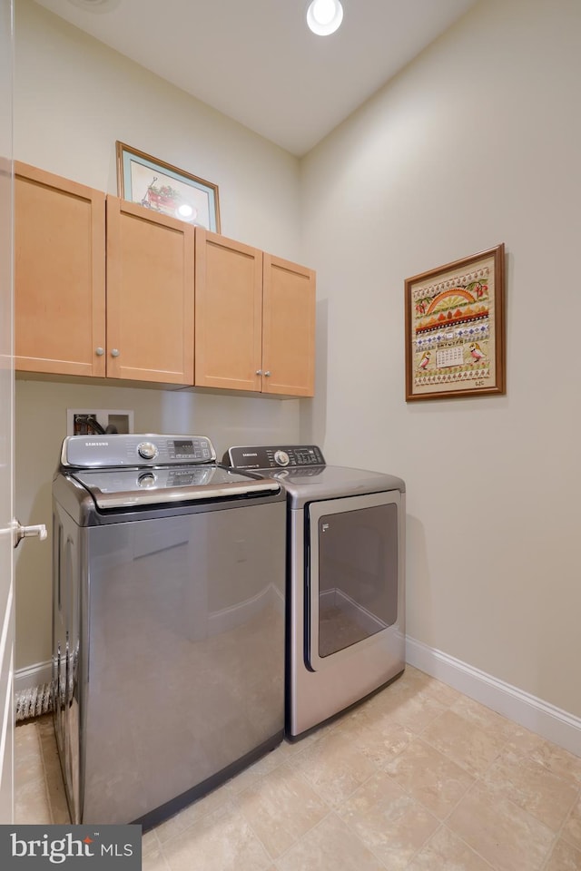 washroom with separate washer and dryer and cabinets