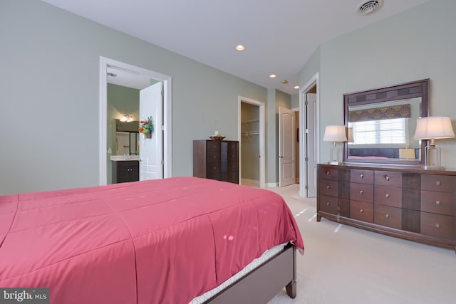 carpeted bedroom with ensuite bathroom, a spacious closet, and a closet