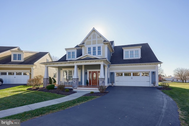 view of front of property featuring a porch, a garage, and a front yard