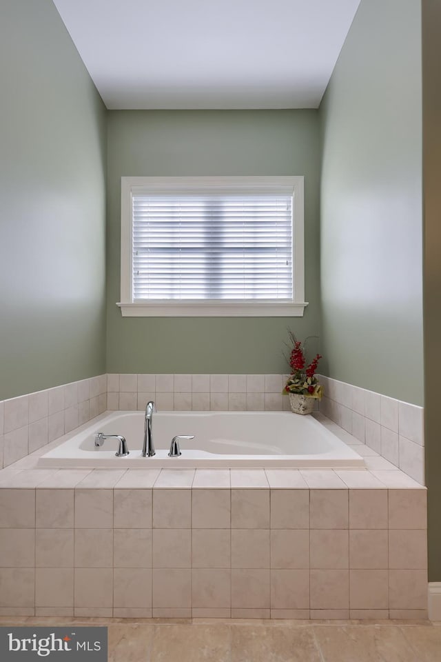 bathroom featuring a relaxing tiled tub and a wealth of natural light