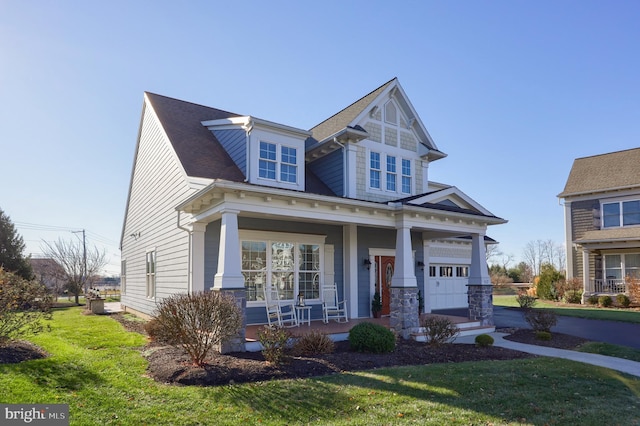 view of front facade featuring a front lawn, a porch, and a garage